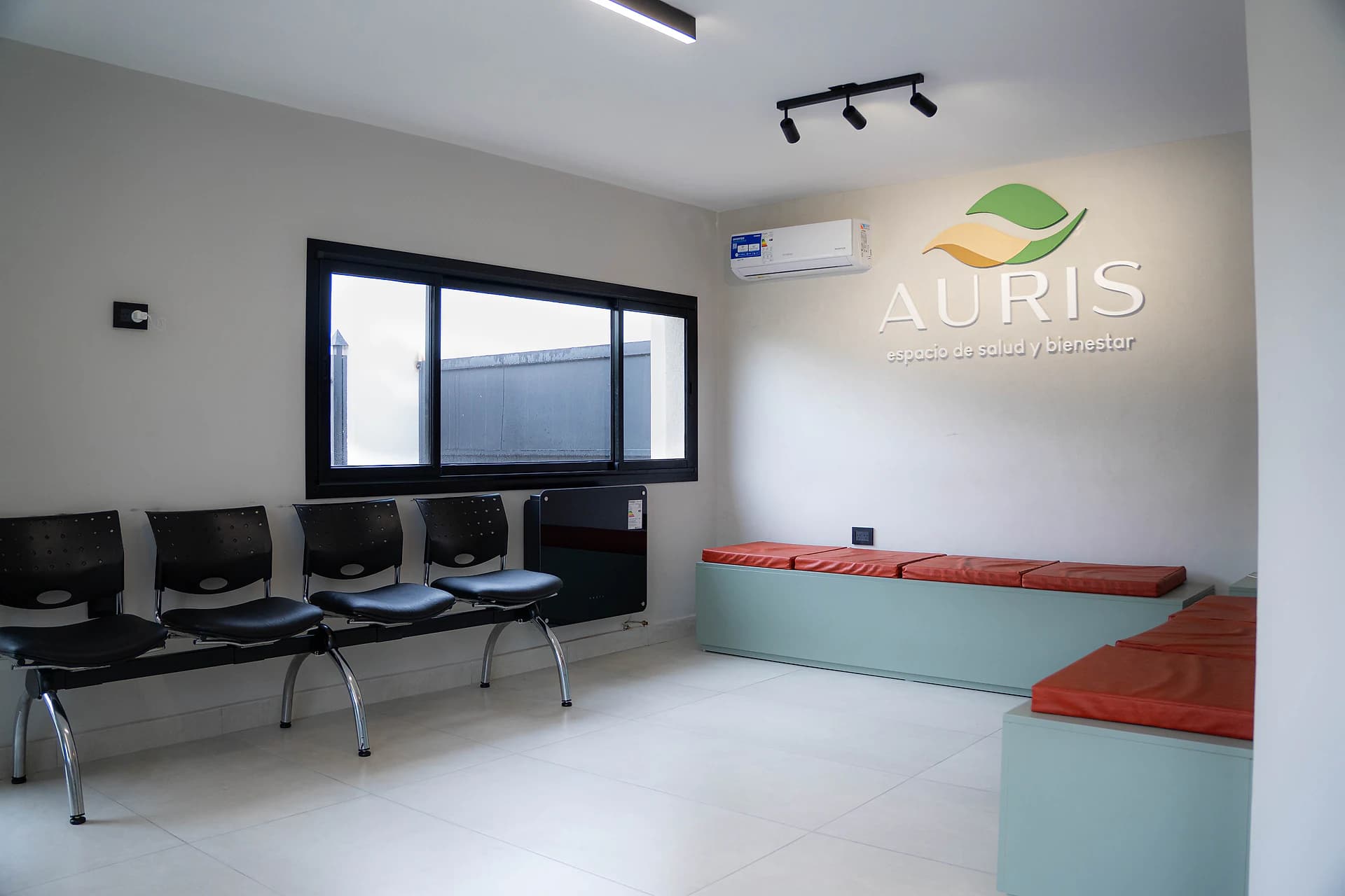 Sala de espera con el logo de AURIS en la pared