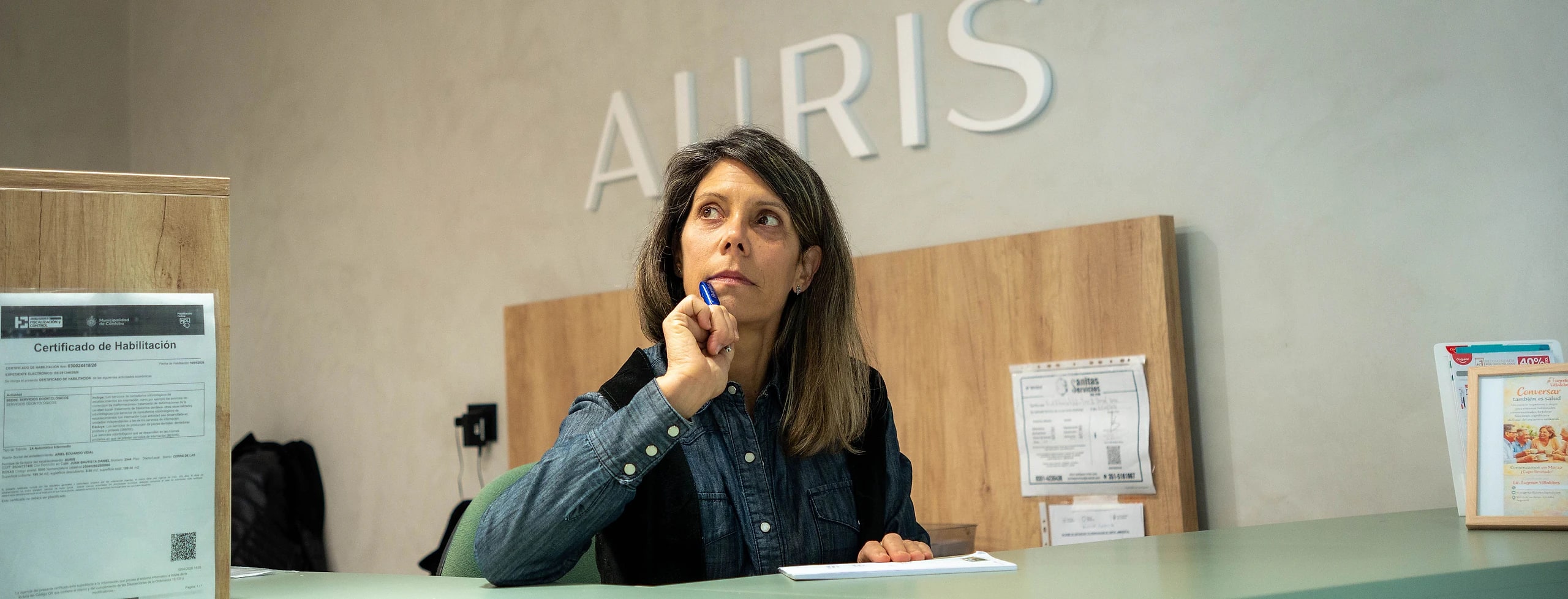 Recepción de AURIS con el cartel del centro en la pared